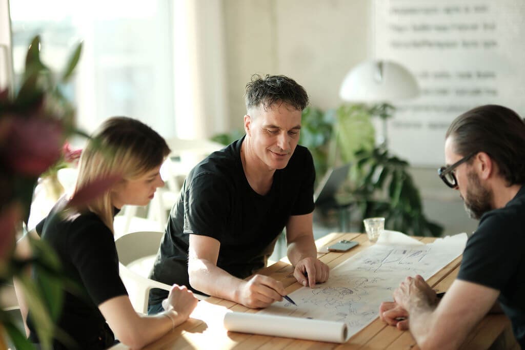 Team von OOW bespricht eine Planzeichnung am Tisch