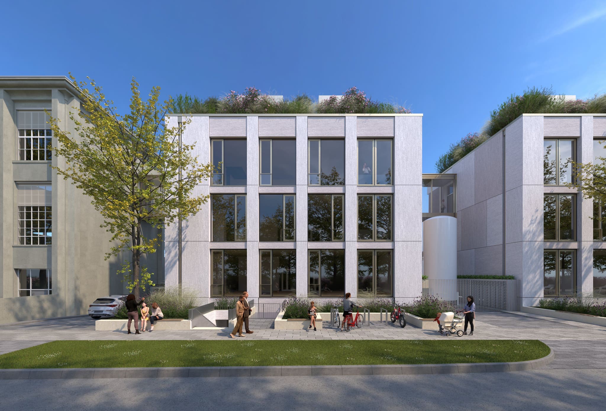 Street view: three-storey new build with pale façade panels and planted roof, old building left, forecourt with bicycles and benches