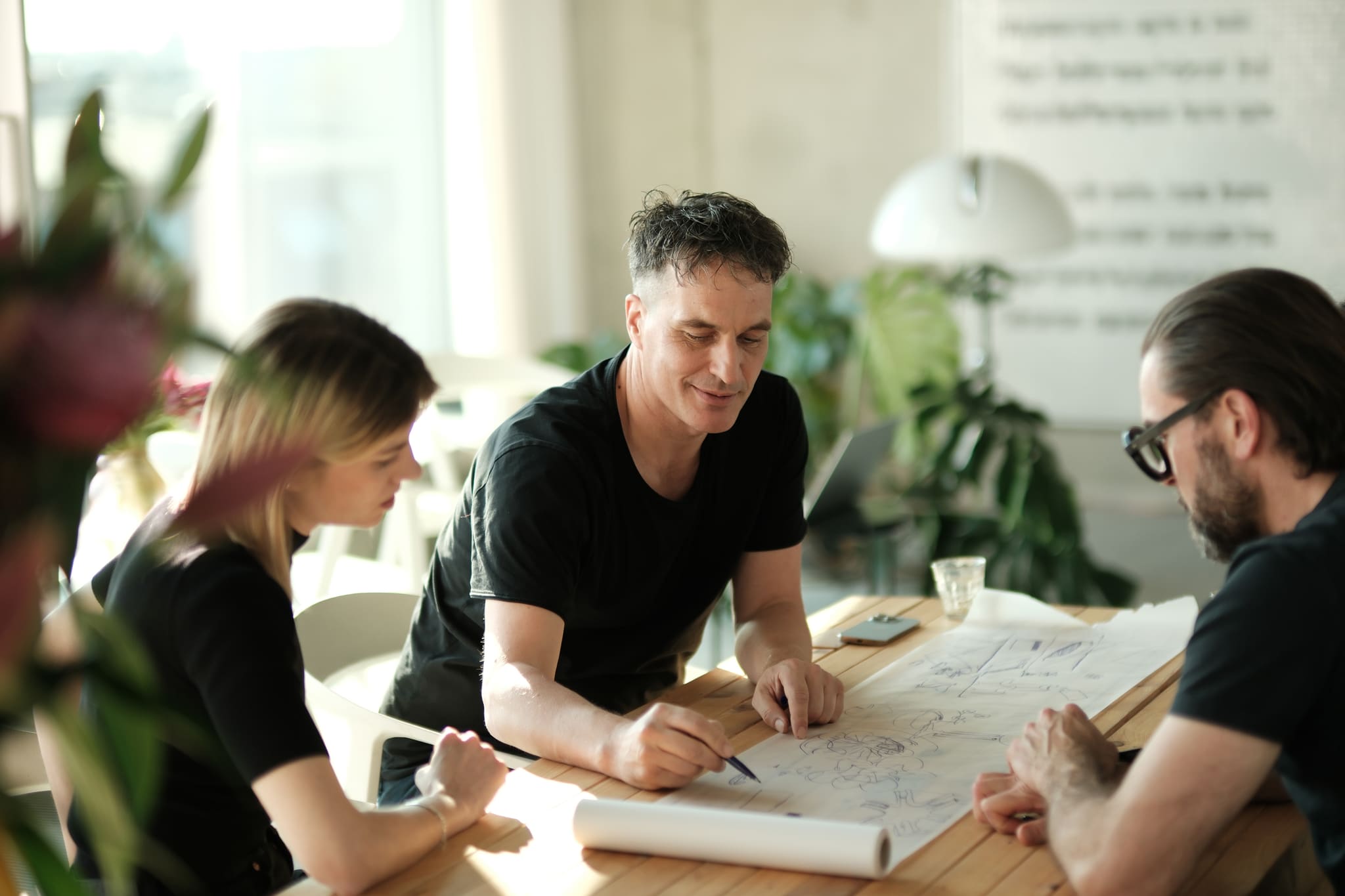Team von OOW bespricht eine Planzeichnung am Tisch